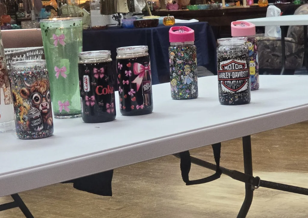 Selection of personalized tumblers displayed together, including colorful glitter and drink-inspired designs